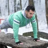Fitness Outdoor training im Winter Mann draußen macht Liegestütze im Winter
